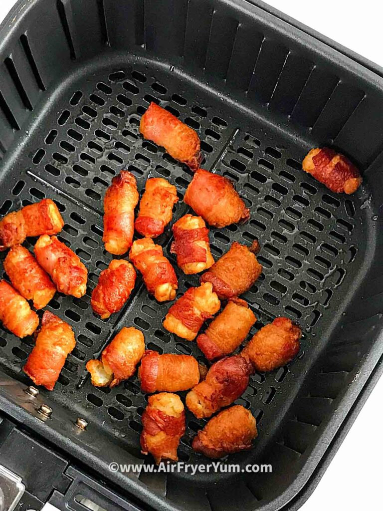 Some tater tots in a black air fryer basket