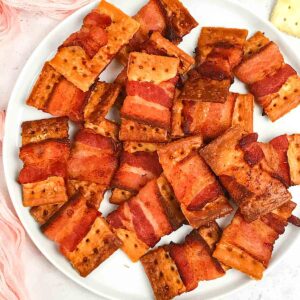 bacon wrapped crackers on a white plate