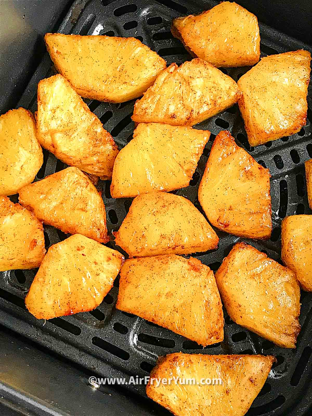 Grilled pineapples in an air fryer basket 
