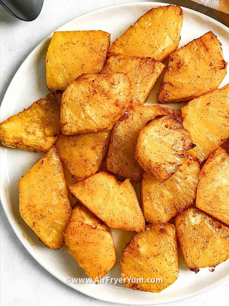 Caramelized pineapple chunks on a white plate 
