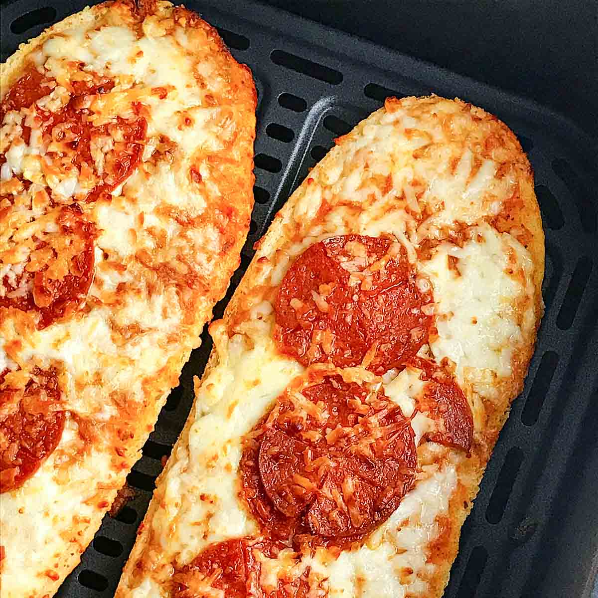 French bread pizza topped with pepperoni in the air fryer basket 